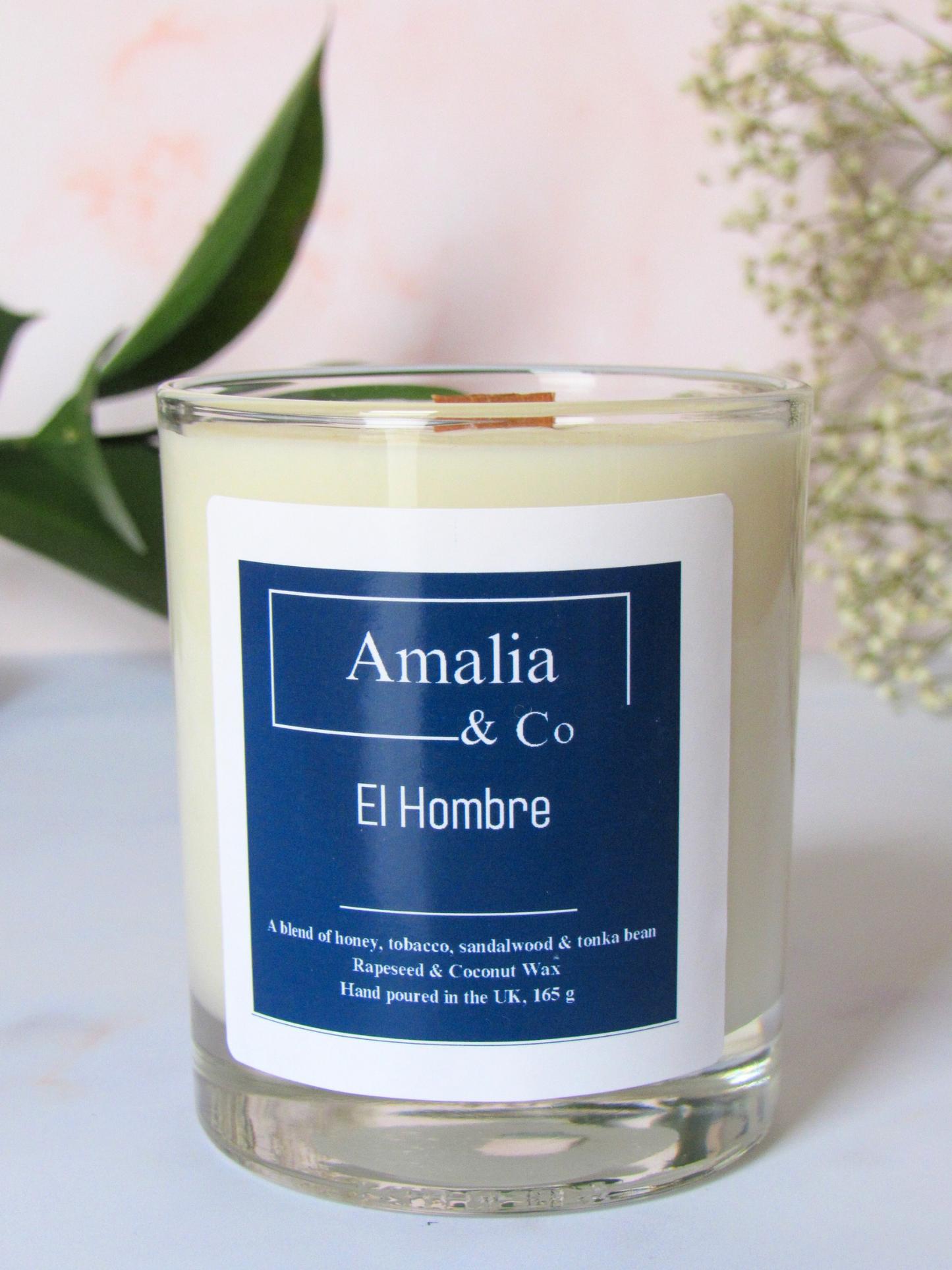 El Hombre luxury candle with tobacco, honey, and citrus top notes, complemented by amber, patchouli, and sandalwood, offering a masculine, warm fragrance.