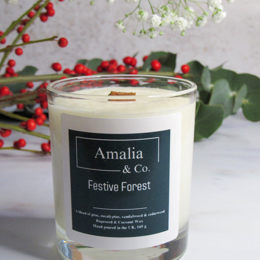 Candle with 'Amalia & Co.' label and festive elements in the background
